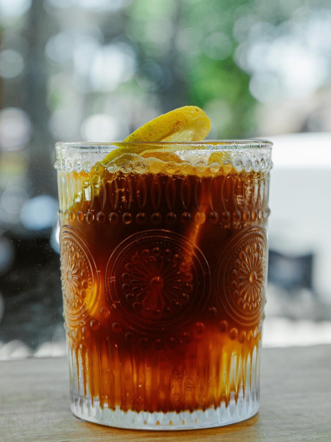 Cold brew en vaso de vidrio tallado con una rodaja de limón